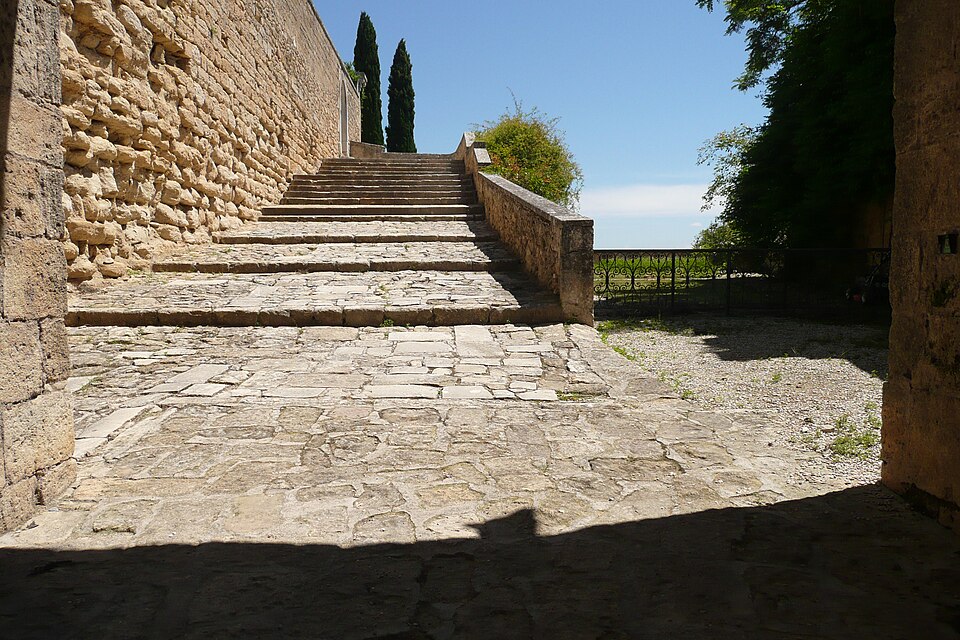 A stone stairway climbing through the village of Ansouis