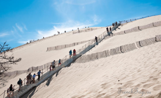 Visitors climbing the wooden staircase up the Dune du Pilat near Arcachon