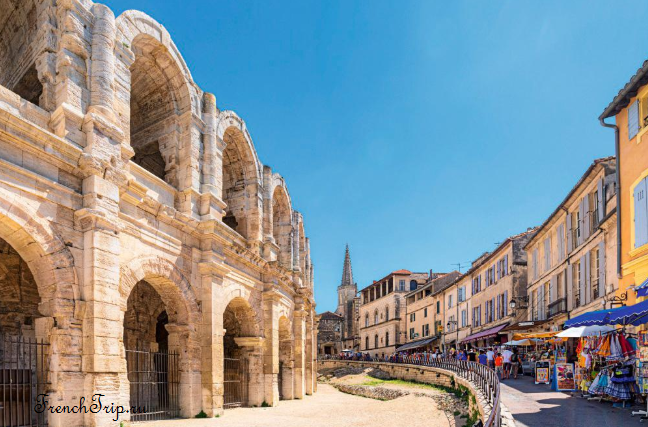 The Roman amphitheatre of Arles rising above the street