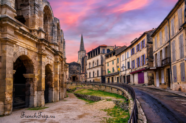 The amphitheatre of Arles at sunset with the old town behind
