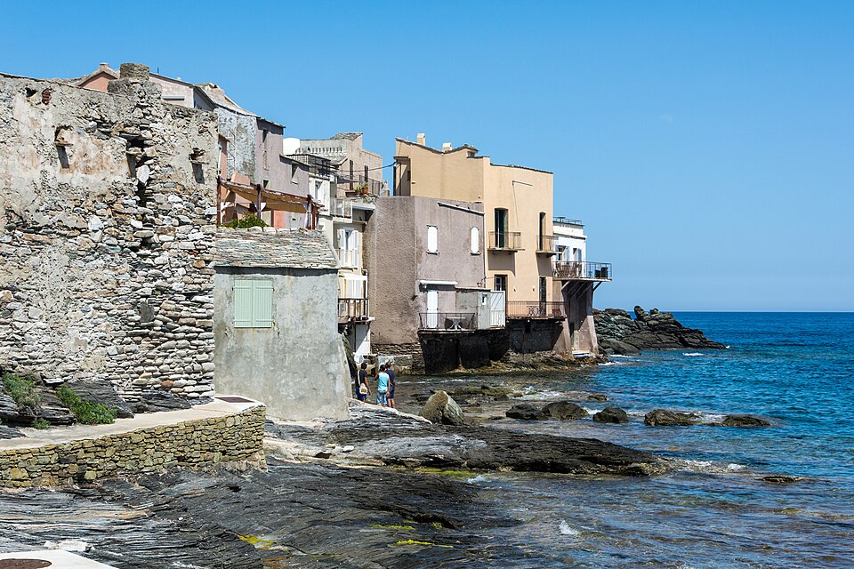 Houses built on the rocks at the water's edge in Erbalunga