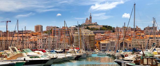 The old port of Marseille with masts and the basilica behind