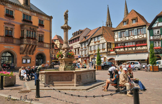 Café terraces around the fountain on the market square of Obernai