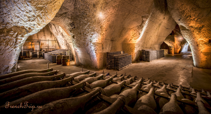 Bottles of champagne ageing in a chalk cellar under Reims