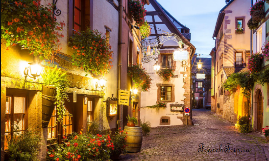 A lit street in Riquewihr in the evening