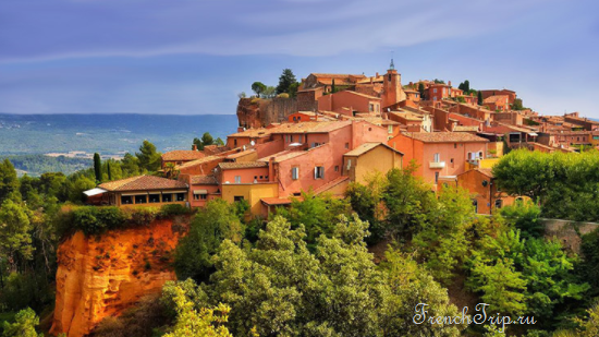The ochre village of Roussillon above its red cliffs