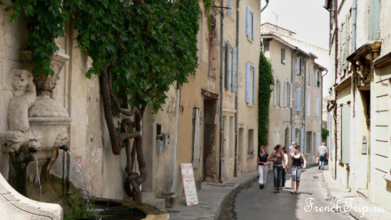 A narrow street with a fountain in Saint-Rémy-de-Provence