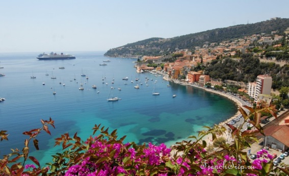 The bay of Villefranche-sur-Mer with a cruise ship at anchor and the old town along the shore