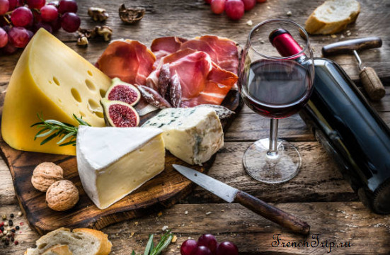 Cheese, charcuterie and red wine on a wooden board